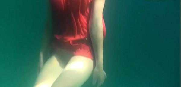  Red dressed mermaid Rusalka swimming in the pool